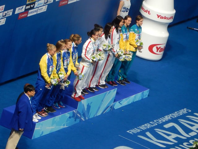 Fu Yuanhui, left on top step, victory ceremony 4 × 100 m medley relay (2015)