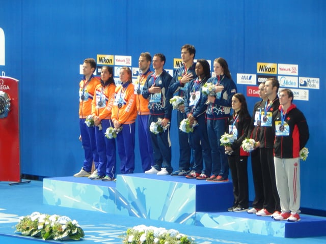 Lochte, Adrian, Manuel, and Franklin (center, left to right) together hold the mixed 4 × 100 m freestyle relay world record.