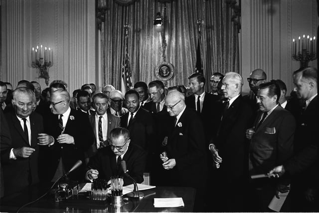 Lyndon B. Johnson signs the historic Civil Rights Act of 1964.