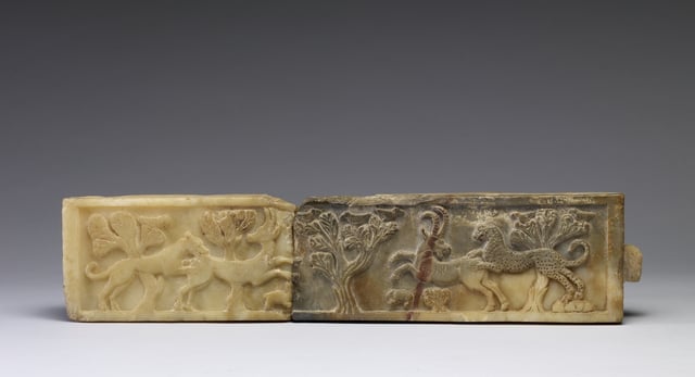 A South Arabian relief from the 5th century BC, in Walters Art Museum. On the left side of this relief, a lion attacks a gazelle, while a rabbit tries to jump away from the gazelle's forelegs. On the right, a leopard jumps down from rocks onto the back of an ibex; a small rodent flees the hoofs of the ibex. Birds in the branches of acacia trees observe the two scenes.