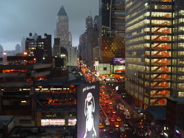 Eighth Avenue, looking northward ("Uptown"), in the rain; most streets and avenues in Manhattan's grid plan incorporate a one-way traffic configuration