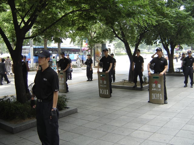 Riot Police of the SMPA stand ready with riot shields