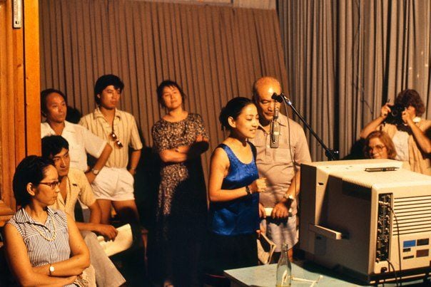 Actors dubbing a television show in China while visitors look on, 1987