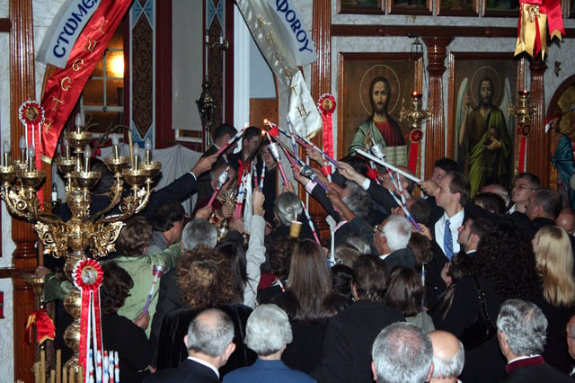The congregation lighting their candles from the new flame, just as the priest has retrieved it from the altar – note that the picture is flash-illuminated; all electric lighting is off, and only the oil lamps in front of the Iconostasis remain lit. (St. George Greek Orthodox Church, Adelaide).