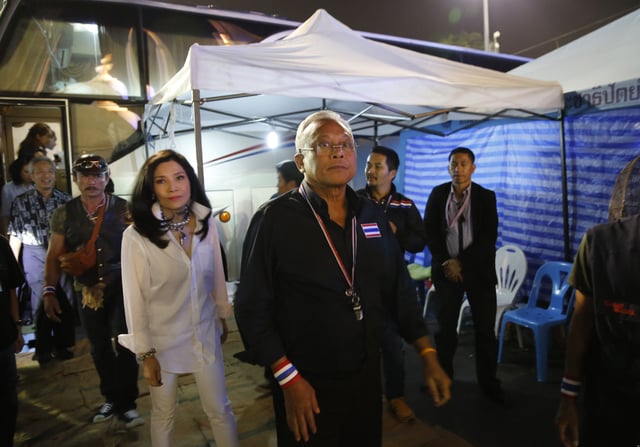 Anti-government protest leader Suthep Thaugsuban, centre, with his wife Srisakul Promphan, in white, arrive at the Democracy Monument, Bangkok, 15 December 2013.