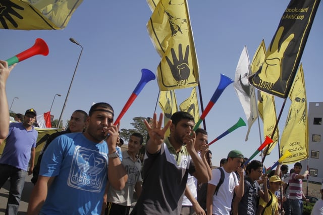 Demonstrators holding the Rabia sign in solidarity with the victims of the August 2013 Rabaa massacre of pro-Morsi sit-ins in Cairo