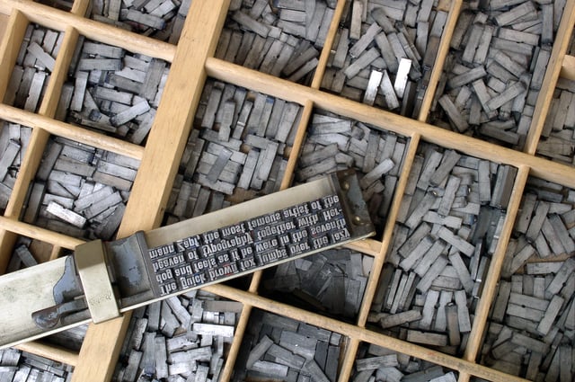 Movable type sorted in a letter case and loaded in a composing stick on top