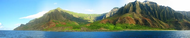 A view of the Nā Pali coastline from the ocean. It is part of the Nā Pali Coast State Park which encompasses 6,175 acres (20 km2) of land and is located on the northwest side of Kauaʻi.