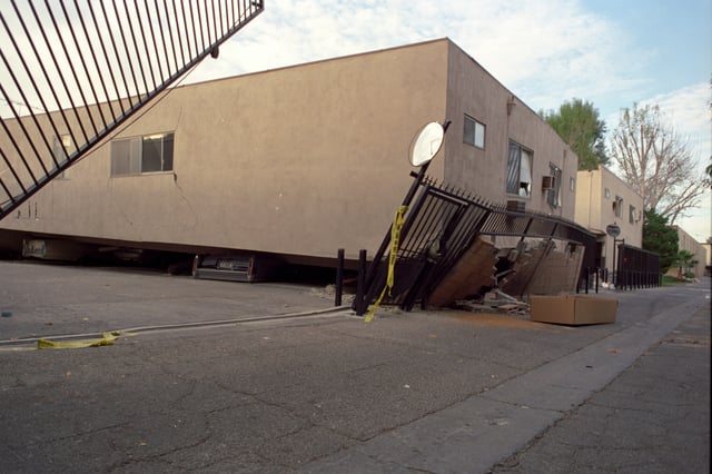 Apartment building that collapsed onto its own footprint, crushing cars parked beneath it