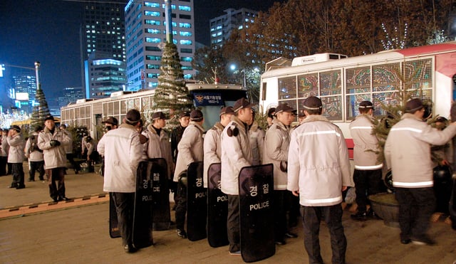 Combat Police officers deployed in the streets of Seoul with their anti-riot shields.