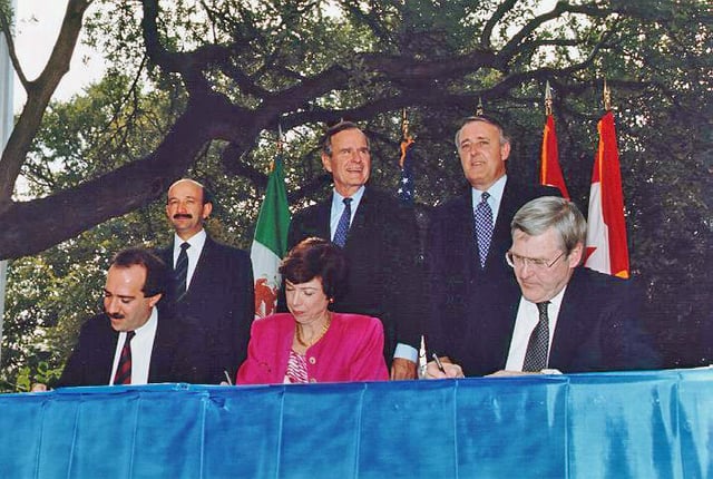 NAFTA signing ceremony, October 1992. From left to right: (standing) President Carlos Salinas de Gortari (Mexico), President George H. W. Bush (U.S.), and Prime Minister Brian Mulroney (Canada); (seated) Jaime Serra Puche (Mexico), Carla Hills (U.S.), and Michael Wilson (Canada)
