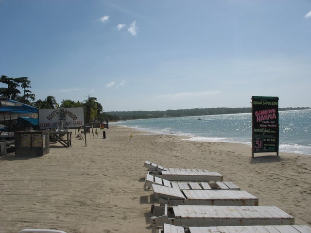 A beach in Negril with a hotel and restaurant