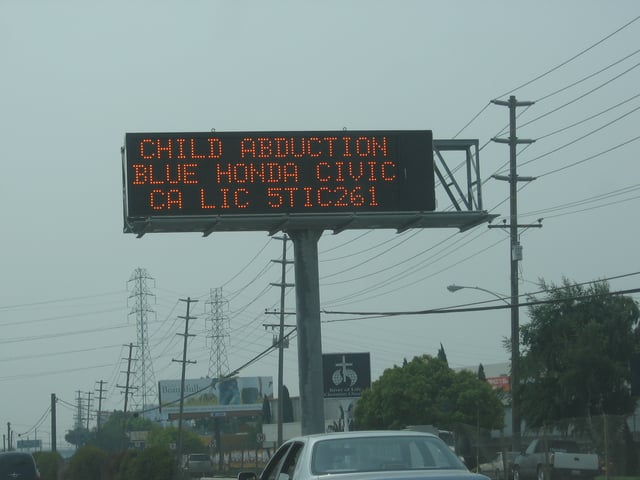 An electronic traffic-condition sign displaying an AMBER Alert. The alleged abductor is the boy's father