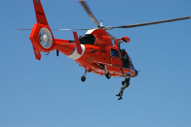 An HH-65 Dolphin demonstrating hoist rescue capability