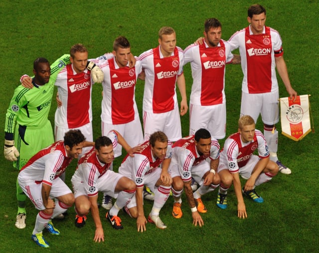 2011 AFC Ajax team wearing their home kit by adidas with the AEGON sponsor across the chest, ahead of their UEFA Champions League match against Olympique Lyonnais.