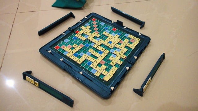 A near-ending game board, tiles and racks of the magnetic Pocket Scrabble (International, Mattel, Inc.)
