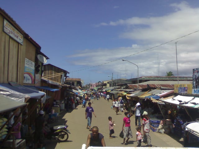 Tausug south/southeast: Main road at Port Holland, Maluso, Basilan, flanked by Tausug traders and market stall owners.