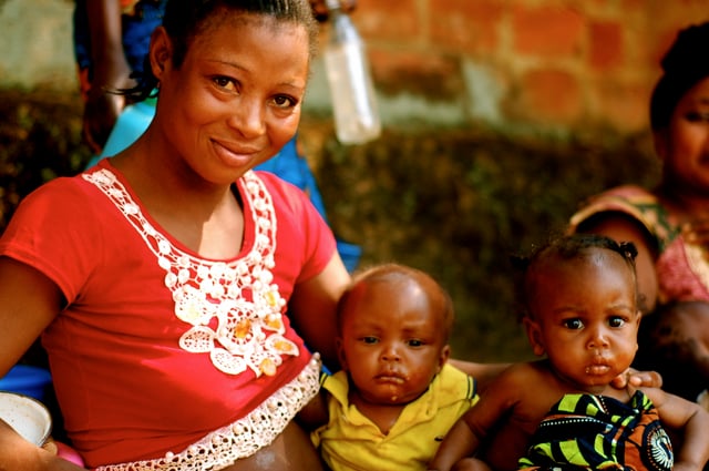 Angolan woman with children outside a health clinic