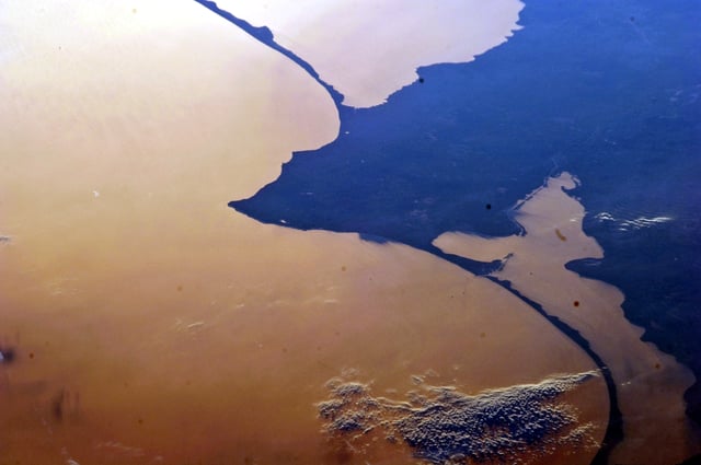 This photograph from the ISS captures the two large lagoons to the north and south of Kaliningrad. The dark blue features are land. (From an astronaut's perspective in low-Earth orbit, land surfaces usually appear brighter than water. But in this image, reflected sunlight, or sunglint, inverts this pattern.)