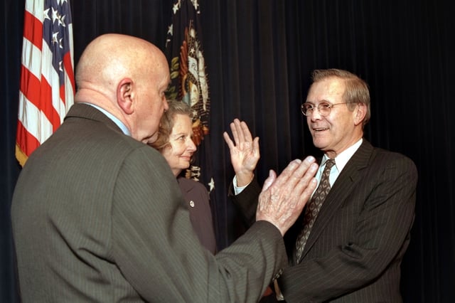 Rumsfeld is administered the oath of office as the 21st Secretary of Defense on January 20, 2001 by Director of Administration and Management David O. Cooke (left), as Joyce Rumsfeld holds the Bible in a ceremony at the Eisenhower Executive Office Building