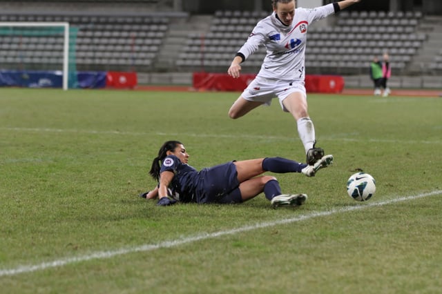 A player executing a slide tackle to dispossess an opponent
