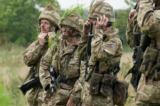 Army Reservists applying camouflage during a training exercise