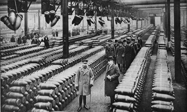 King George V (front left) and a group of officials inspect a British munitions factory in 1917.