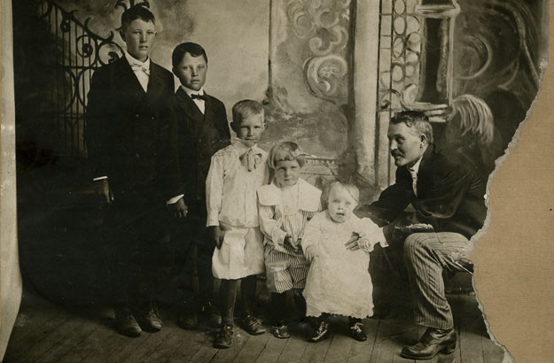 Gaskell Romney, sitting, and family, of Colonia Dublan, Chihuahua, c. 1908. Son George is fourth from the left.