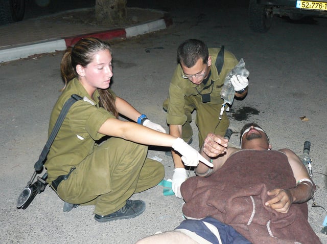 IDF soldiers treat an injured Palestinian man
