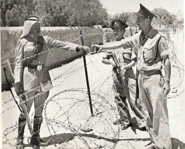 Israeli policemen meet a Jordanian Legionnaire near the Mandelbaum Gate (circa 1950)