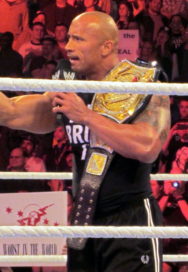 The Rock is a ten-time world champion, pictured here with the WWE Championship in 2013