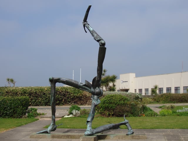 A sculpture of the Manx triskelion in front of Ronaldsway Airport terminal