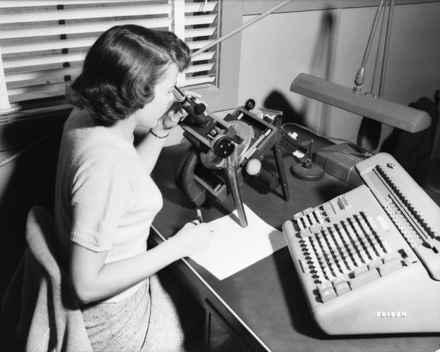 A female computer, with microscope and calculator, 1952