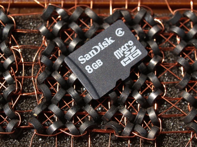 This microSDHC card holds 8 billion bytes. Beneath it is a section of a magnetic-core memory (used until the 1970s) that holds eight bytes using 64 cores.  The card covers approximately 20 bits (2 1/2 bytes)