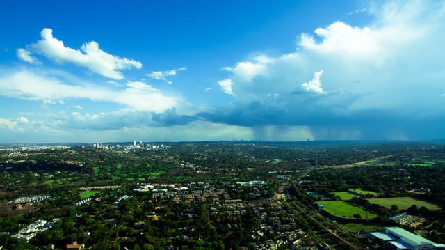 An aerial photograph of summer rain clouds over Johannesburg. The city's climate experiences regular daily thunderstorms from November to March in the afternoons.