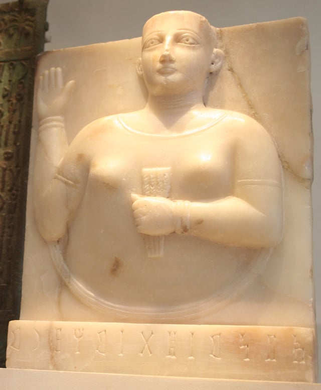 A Sabaean gravestone of a woman holding a stylized sheaf of wheat, a symbol of fertility in ancient Yemen