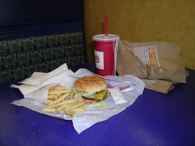 A meal including small French fries, a Whopper Jr., a drink, and packets of Heinz ketchup.