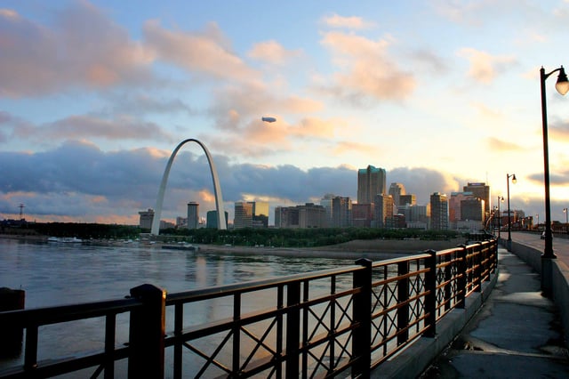 A cluster of skyscrapers is located just west of the Gateway Arch and the Mississippi River.