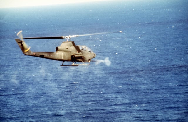 A U.S. Army AH-1S Cobra attack helicopter opens fire on an enemy position