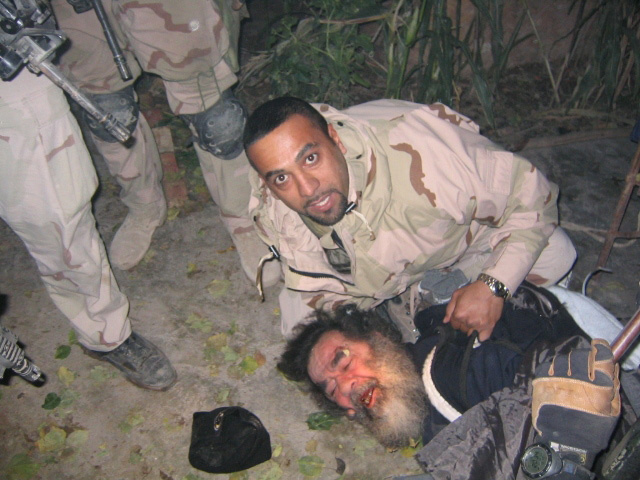 Saddam Hussein being pulled from his hideaway in Operation Red Dawn, 13 December 2003
