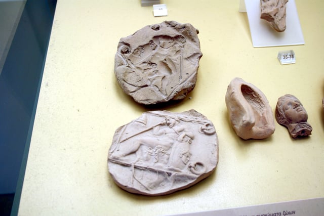 Ancient Greek molds, used to mass-produce clay figurines, 5th/4th century BC. Beside them, the modern casts taken from them. On display in the Ancient Agora Museum in Athens, housed in the Stoa of Attalus.