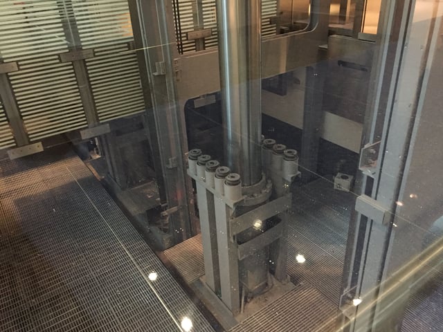 Pit of a hydraulic scenic elevator with metal grating on bottom.