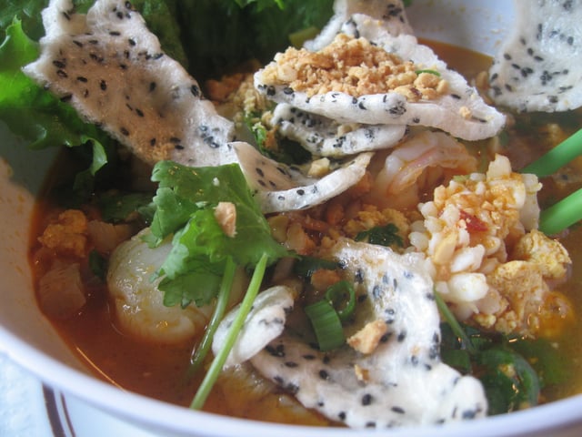 Baked sesame banh trang topped in mi quang