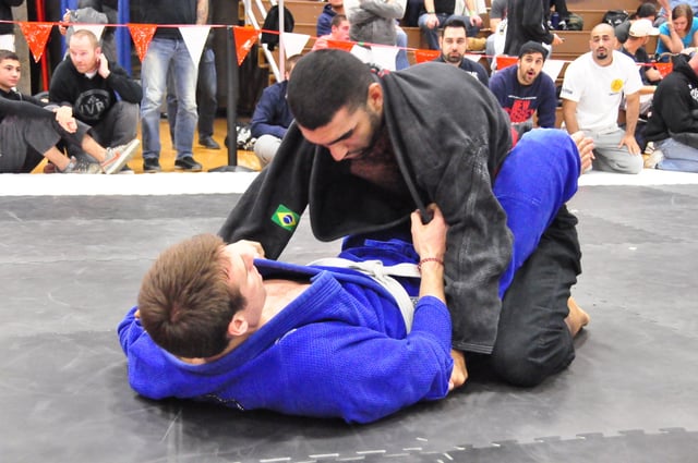 The Jiu-Jitsu practitioner in blue is demonstrating a type of closed guard