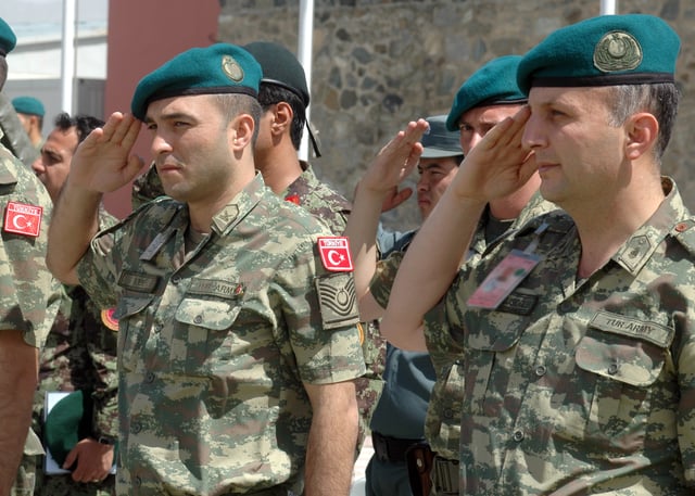 Turkish soldiers salute while the band plays the national anthem.