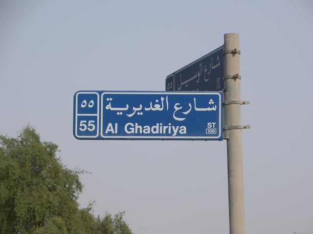 A typical bilingual traffic sign in Doha denotes the zone numbers, street names and street numbers of two perpendicular streets.