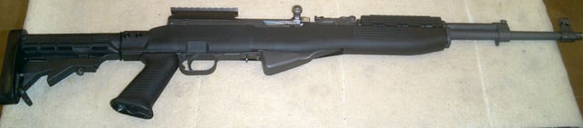 A sporterized SKS carbine fitted with an aftermarket composite stock and weaver rail.