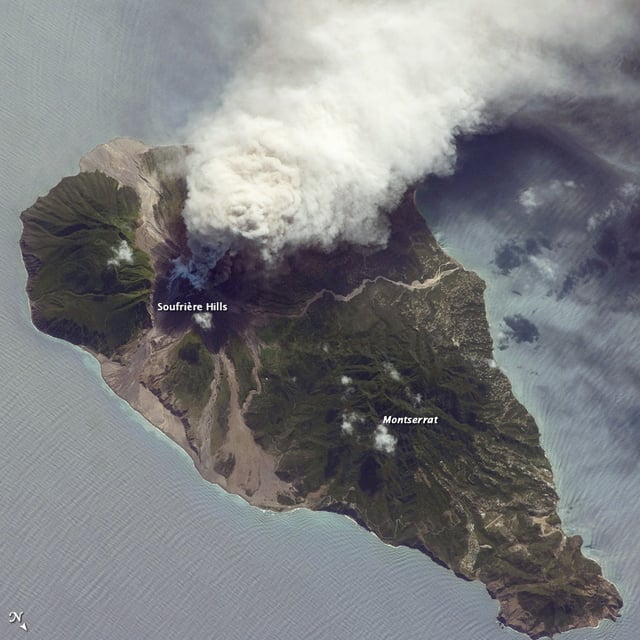 2009 ash and steam plume, Soufrière Hills Volcano. Grey deposits that include pyroclastic flows and volcanic mudflows (lahars) are visible extending from the volcano toward the coastline. NASA ISS photo, 11 October 2009, a view from the northeast looking southwest