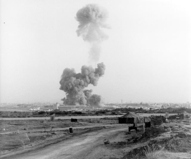 A smoke cloud rises from the bombed American barracks at Beirut International Airport, where over 200 U.S. marines were killed