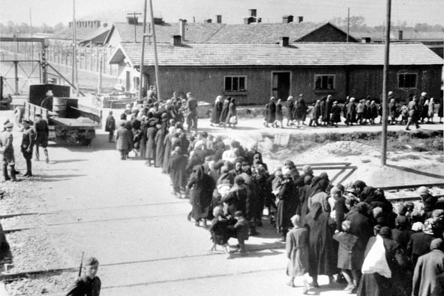Jewish women and children from Subcarpathian Rus walking toward the gas chamber, Auschwitz II, May/June 1944. The gate on the left leads to sector BI, the oldest part of the camp.